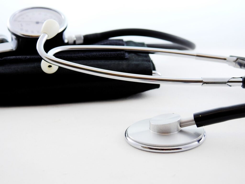 A close-up of a stethoscope and a blood pressure cuff on a white background.