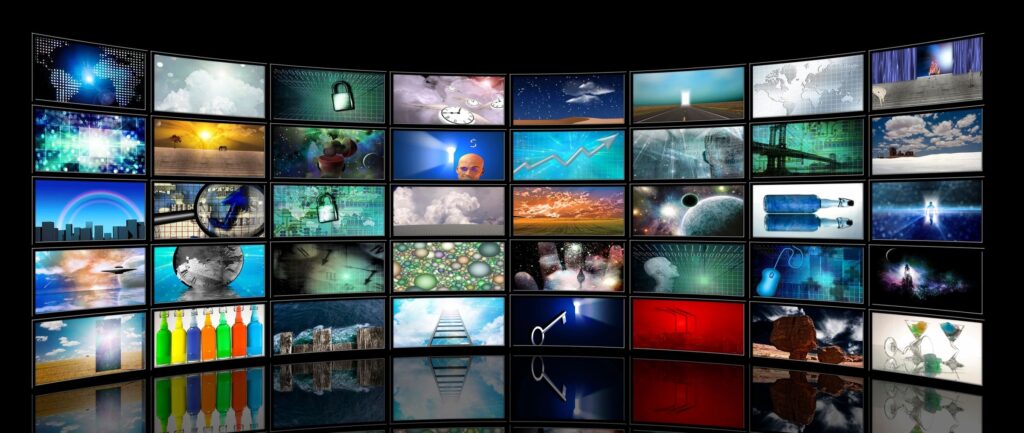 A curved wall of screens displaying various images, including graphs, landscapes, and abstract visuals.