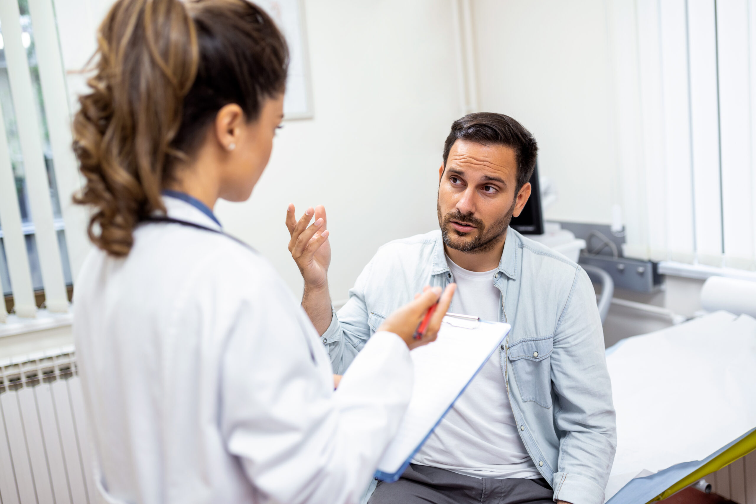 A doctor consulting a male patient in a medical office.